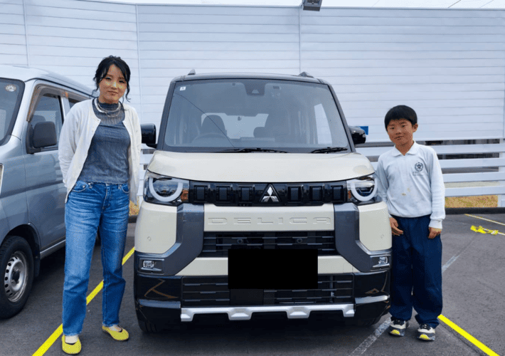 車と写真を撮るお母さんと子供